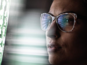 Female data analyst looking at data on screen, reflection in glasses. Female data analyst looking at data on screen, reflection in glasses.